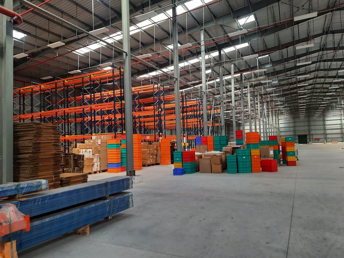 Warehouse and logistics hub with stacked pallets, shelving, and industrial flow.